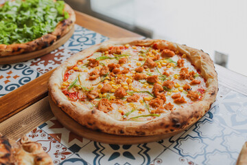 Hot tasty traditional various italian pizzas with salami, meat, cheese, onion, mushroom, tomatoes greens on a dark background