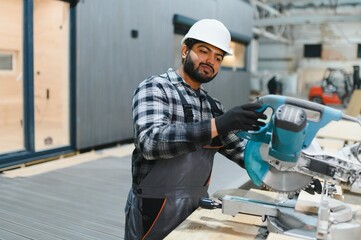Indian carpenter works on the construction of modular houses