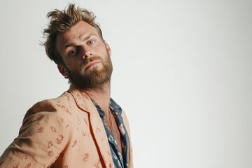 Obraz premium Stylish Young Man with Beard in Trendy Outfit Posing Against a Neutral Background