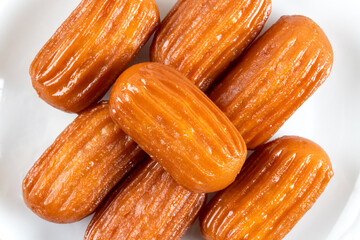 Traditional Turkish dessert tulumba on a plate. Tulumba dessert, fried in oil and soaked in syrup
