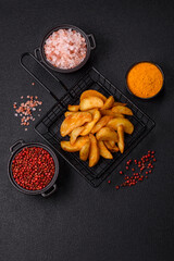 Baked potato wedges with cheese and herbs on a dark background
