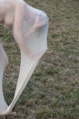 artistic photo of part of young sexy elegant nude woman, her body wrapped in long skin tight white...