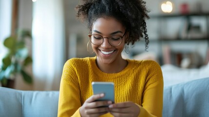 Happy woman reading text message on mobile phone at home.