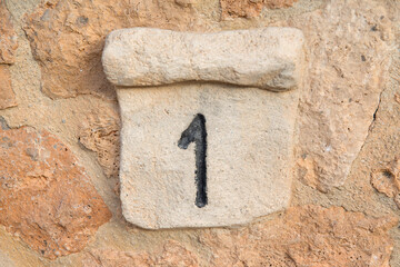 Stone plaque with the number 1 written.