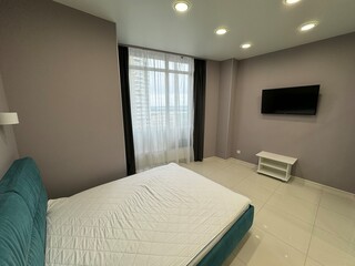 Modern minimalist bedroom with cozy lighting and city view