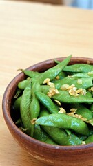 A bowl of edamame, japanese beans associated with healthy food and lifestyle, seasoned with garlic butter sauce