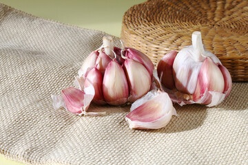 Garlic in front of a wicker basket on the jute fabric. Brazilian ingredient present in culinary from Brazil.