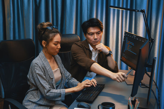 IT developers discussing with point to intelligent website development coder system running data online two screens information technology at neon light room at modern office. Infobahn.