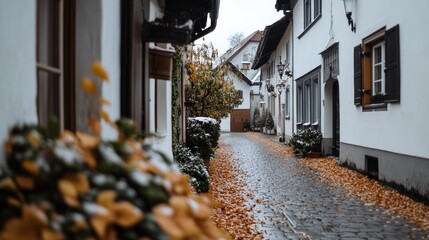 A quaint cobblestone street lined with charming cottages and fallen autumn leaves, enveloped in a crisp, nostalgic village vibe.