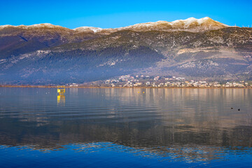 Mountains Watch Over Ioannina Lake in Epirus, Greece. Reflective waters. Birdwatching hide