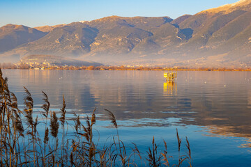 Mountains Watch Over Ioannina Lake in Epirus, Greece. Reflective waters. Birdwatching hide 