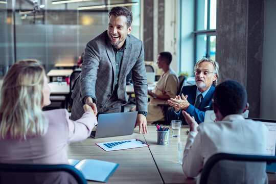 Business professionals shaking hands during a team meeting