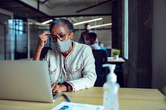 Black businesswoman wearing mask in office meeting - Powered by Adobe