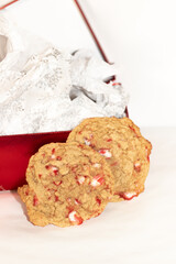 Two oatmeal cookies with red peppermint candy pieces in Christmas in makeshift studio