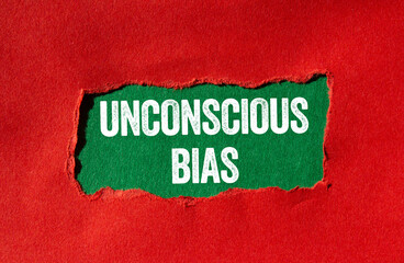 Unconscious bias message written on ripped torn red paper on green background. Conceptual...
