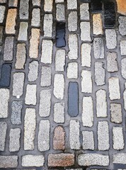 Background: Uneven old wall with different colored patched clinker bricks. Closeup. Walls of...