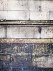 Background: Uneven old wall with different colored patched clinker bricks. Closeup. Walls of...