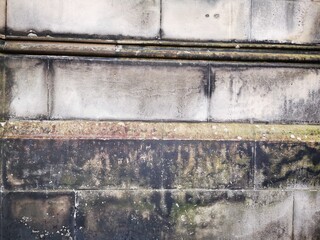 Background: Uneven old wall with different colored patched clinker bricks. Closeup. Walls of...
