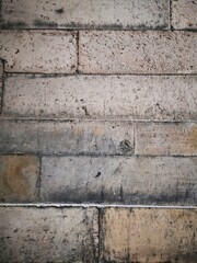 Background: Uneven old wall with different colored patched clinker bricks. Closeup. Walls of...