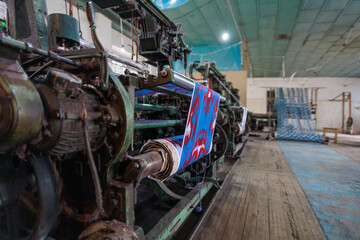 A loom with a carpet in the process of sewing.