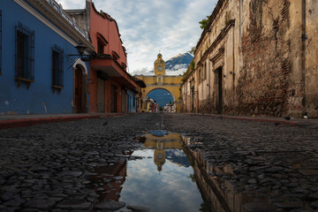Old Santa Catalina bridge, with the volcano in the background, in the city of Antigua, Guatemala