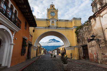 Old Santa Catalina bridge, with the volcano in the background, in the city of Antigua, Guatemala
