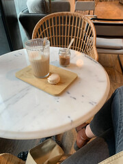Ugc flat lay in cafe: latte and macaron on marble table