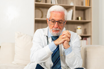 Fototapeta premium Sad tired mature senior male doctor in medical uniform in hospital or doctor office. Unhappy General Practitioner GP therapist professional healthcare expert in clinic. Healthcare concept