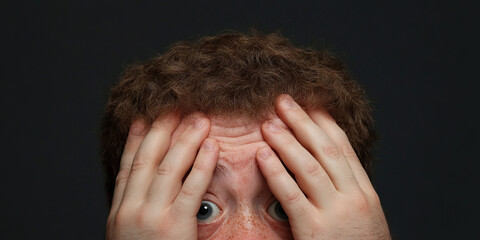 Fototapeta premium Close-up Photograph of a Man with Hands Covering Eyes