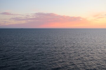 Die Sonne ist untergegangen über dem Skagerrak und taucht den Himmel in ein orangenes und lilafarbenes Licht. Es ist ein Sommerabend und das Meer ist ruhig.