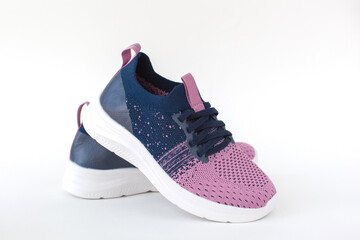 Stylish knit children's sneakers in pink and navy blue with white soles, isolated on a white background, perfect for casual wear and active lifestyles