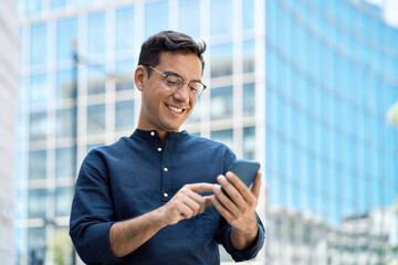 Happy young Hispanic business man manager using financial banking mobile apps on cell phone...