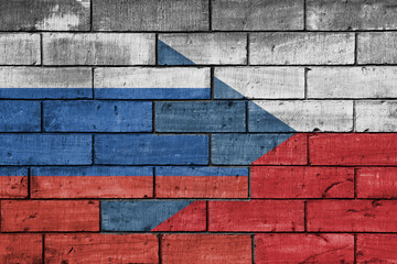 colourful painted big flag of russia and flag of czech republic on a massive old brick wall...