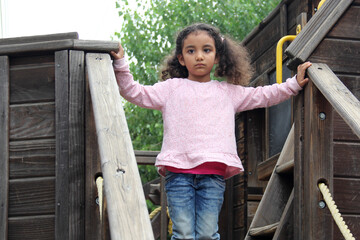 4 year old Latina girl with brunette and curly hair plays in the outdoor park games as therapy and treatment for attention deficit hyperactivity disorder