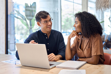 Happy busy African business woman and Hispanic business man talking in office working together on...