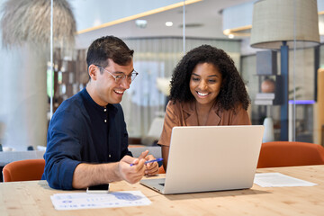 Smiling team professional employees working together on computer discussing online technology data...