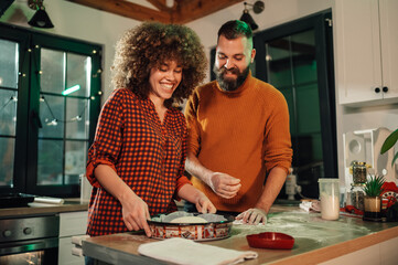 Happy couple preparing dough for baking at home
