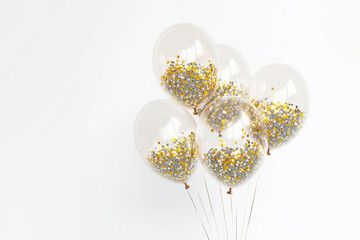 Fototapeta premium Elegant transparent balloons filled with gold and silver confetti make a great decoration for celebrations and events