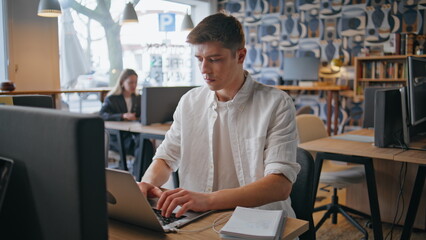Involved employee texting computer work in office closeup. Man typing laptop