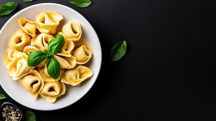 Cheese tortellini on white plate garnished with fresh basil leaves
