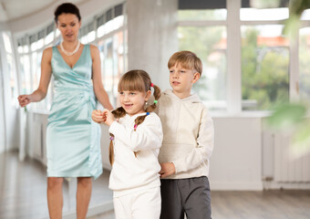 Couple of positive interested preteen dancers, boy and girl preparing for performance, rehearsing...