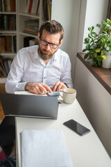 Fototapeta premium Millennial businessman working at desk in office