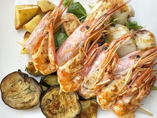 Grilled prawns and vegetables on a white plate
