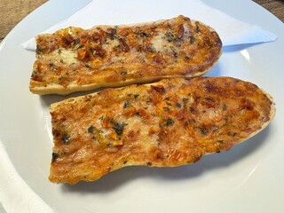 Italian bruschetta with tomato and herb topping on white plate