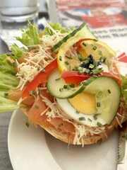 Fresh open-faced bagel with salmon, cheese, egg, and vegetables