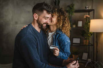 satisfied couple do online shopping over mobile phone with credit card