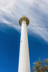 Obraz premium Lighthouse on Dzharylhach Island and a small white building on a sandy beach