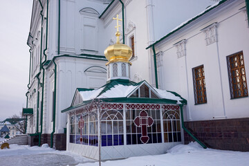 Small building with a cross on it and a gold roof