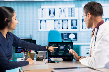 Indian healthcare professional sharing medical expertise with a patient in office, examining x ray...
