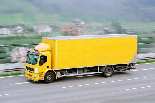 Accelerating Yellow Cargo Truck With Big Space Capacity For Goods Products Transportation And Moving